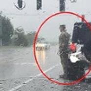 Egy nő észrevette, hogy egy katona áll a zuhogó esőben.